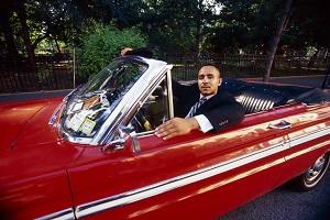 man sitting in a red classic car